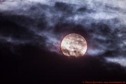 Weißlicht-Aufnahme der Sonne mit vorüberziehendem Merkur hinter atmosphärischen Wolken (München), 500mm Brennweite